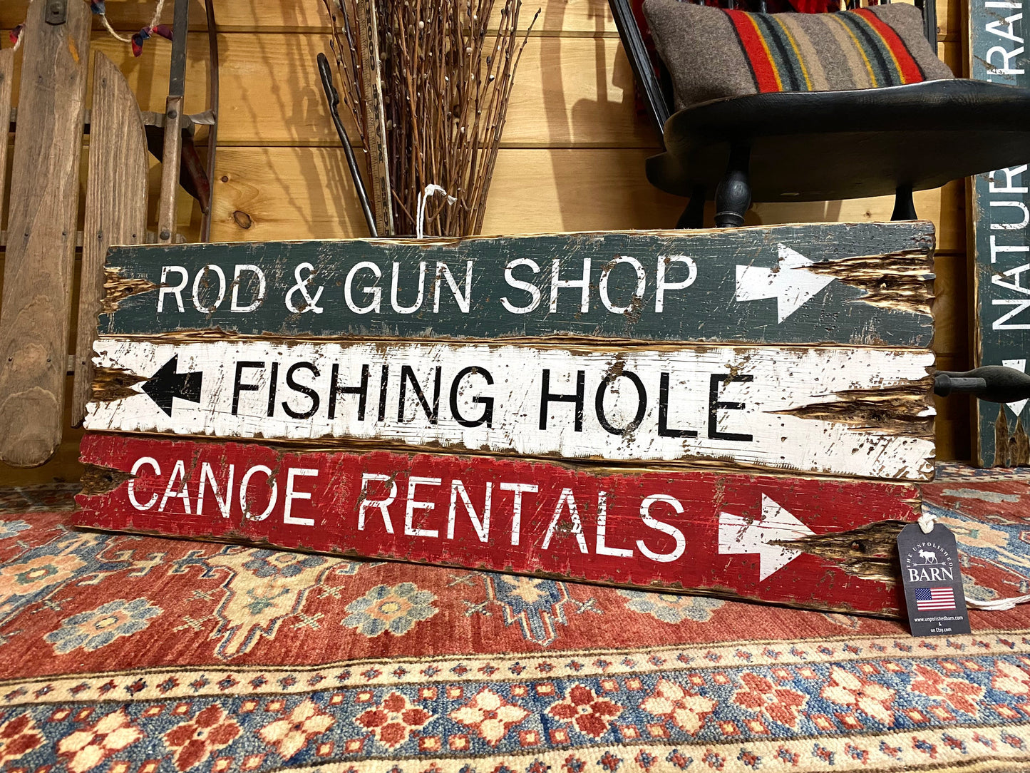 Handmade rustic wood fishing lodge sign with rod and gun shop, fishing hole, and canoe rentals design, vintage cabin wall art made in Maine.
