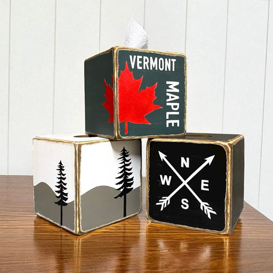 Rustic wooden tissue box covers with Vermont maple leaf design, compass arrows, and mountain tree silhouette artwork, farmhouse cabin style home décor