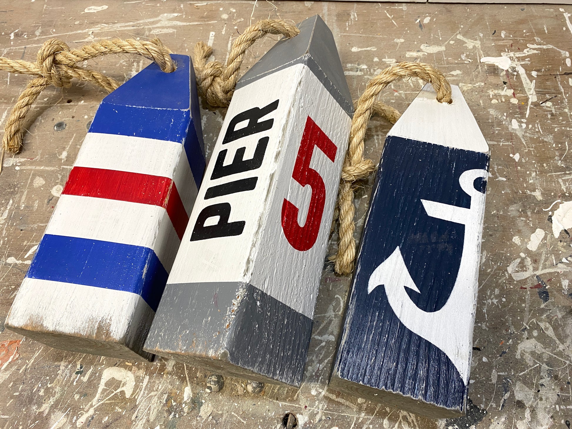 Close-up of Pier 5 nautical lobster wood buoy featuring hand-painted lobster design, distressed wood finish, rustic coastal decor, New England nautical decor, beach house decor, boating decor, sailing gift, harbor decor, and waterfront home accent.