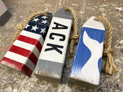 Detailed view of Nantucket wood buoy decor featuring coastal artwork, handmade painted details, and nautical character. Perfect for beach house decor, coastal homes, ocean-inspired rooms, and seaside cottages.