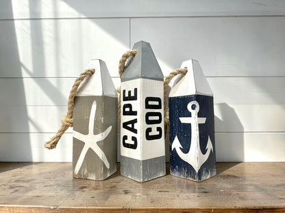Hand-painted Cape Cod nautical buoy decor featuring starfish, anchor, and rustic coastal details. Coastal home decor for beach-themed rooms, seaside cottages, and ocean-inspired spaces