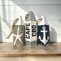 Hand-painted Cape Cod wood buoy set featuring starfish and anchor designs with a distressed finish. Nautical coastal decor for beach houses, coastal cottages, beach-themed rooms, seaside homes, and waterfront spaces.