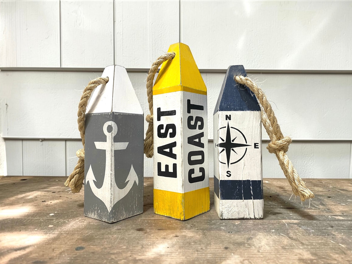 Decorative East Coast nautical buoy set displayed in a coastal home with rustic seaside decor. Inspired by harbors, docks, boating, sailing, and New England coastal style.