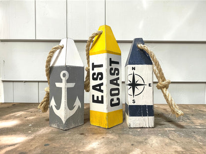 Decorative East Coast nautical buoy set displayed in a coastal home with rustic seaside decor. Inspired by harbors, docks, boating, sailing, and New England coastal style.