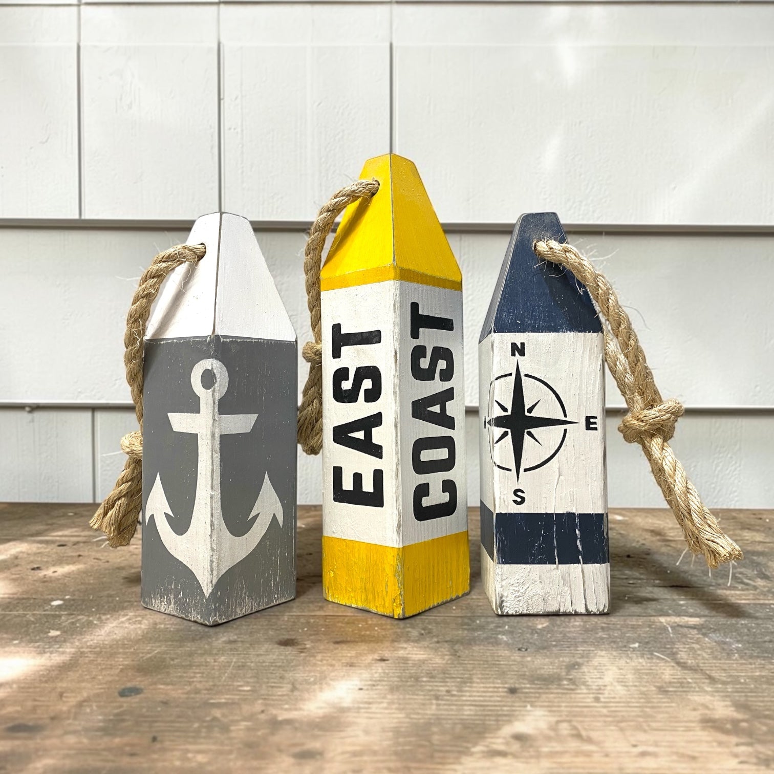 Decorative East Coast buoy set displayed in a beach house with nautical coastal decor. Handmade wood accents for beach houses, seaside cottages, coastal rooms, and waterfront retreats.