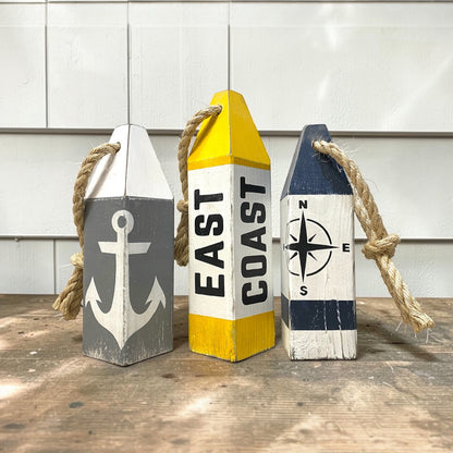 Decorative East Coast buoy set displayed in a beach house with nautical coastal decor. Handmade wood accents for beach houses, seaside cottages, coastal rooms, and waterfront retreats.