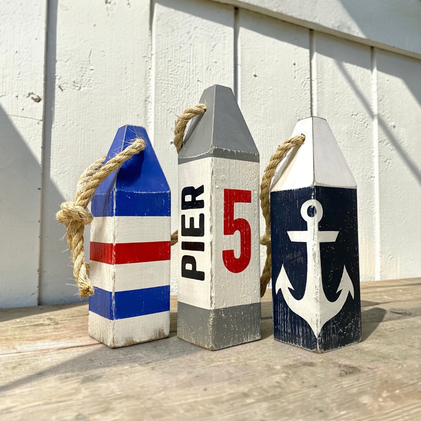 Hand-painted Pier 5 nautical lobster wood buoy with rustic distressed finish and coastal design. Handmade coastal decor inspired by New England harbors, perfect for coastal homes, beach houses, boating spaces, sailing gifts, and waterfront retreats
