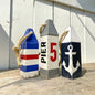 Hand-painted Pier 5 nautical lobster wood buoy with rustic distressed finish and coastal design. Handmade coastal decor inspired by New England harbors, perfect for coastal homes, beach houses, boating spaces, sailing gifts, and waterfront retreats