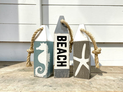 Beach buoy set displayed in a nautical home with ocean-inspired decor. Handmade wood accents for beach houses, coastal cottages, seaside retreats, and coastal living spaces