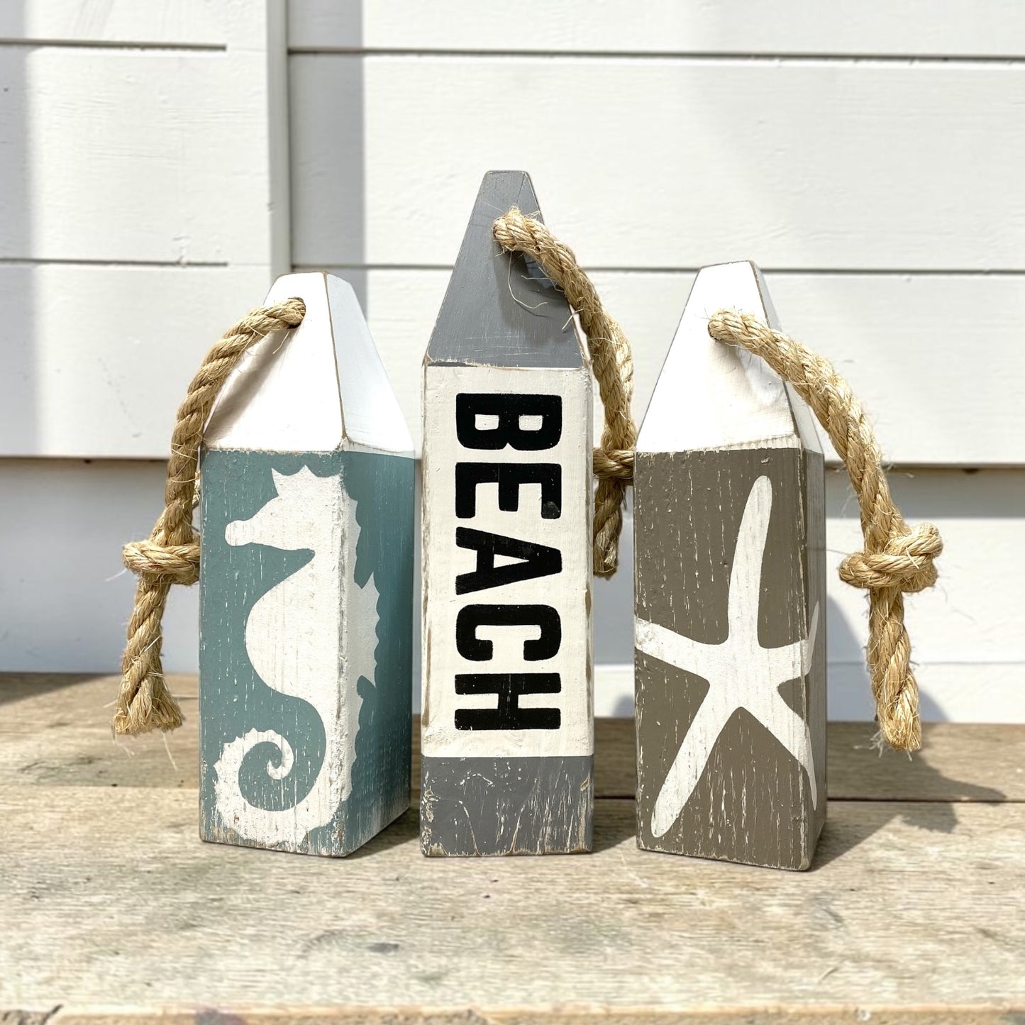 Hand-painted nautical beach buoy decor featuring seahorse and starfish details. Coastal home decor for beach-themed rooms, ocean rooms, cottages, and waterfront homes.