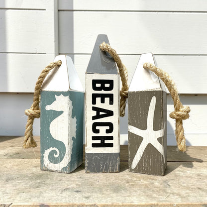 Hand-painted nautical beach buoy decor featuring seahorse and starfish details. Coastal home decor for beach-themed rooms, ocean rooms, cottages, and waterfront homes.