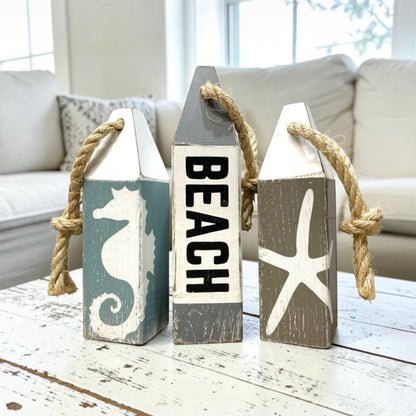 Hand-painted beach wood buoy set featuring seahorse and starfish designs with a distressed finish. Nautical coastal decor for beach houses, coastal cottages, beach-themed rooms, seaside homes, and ocean-inspired spaces
