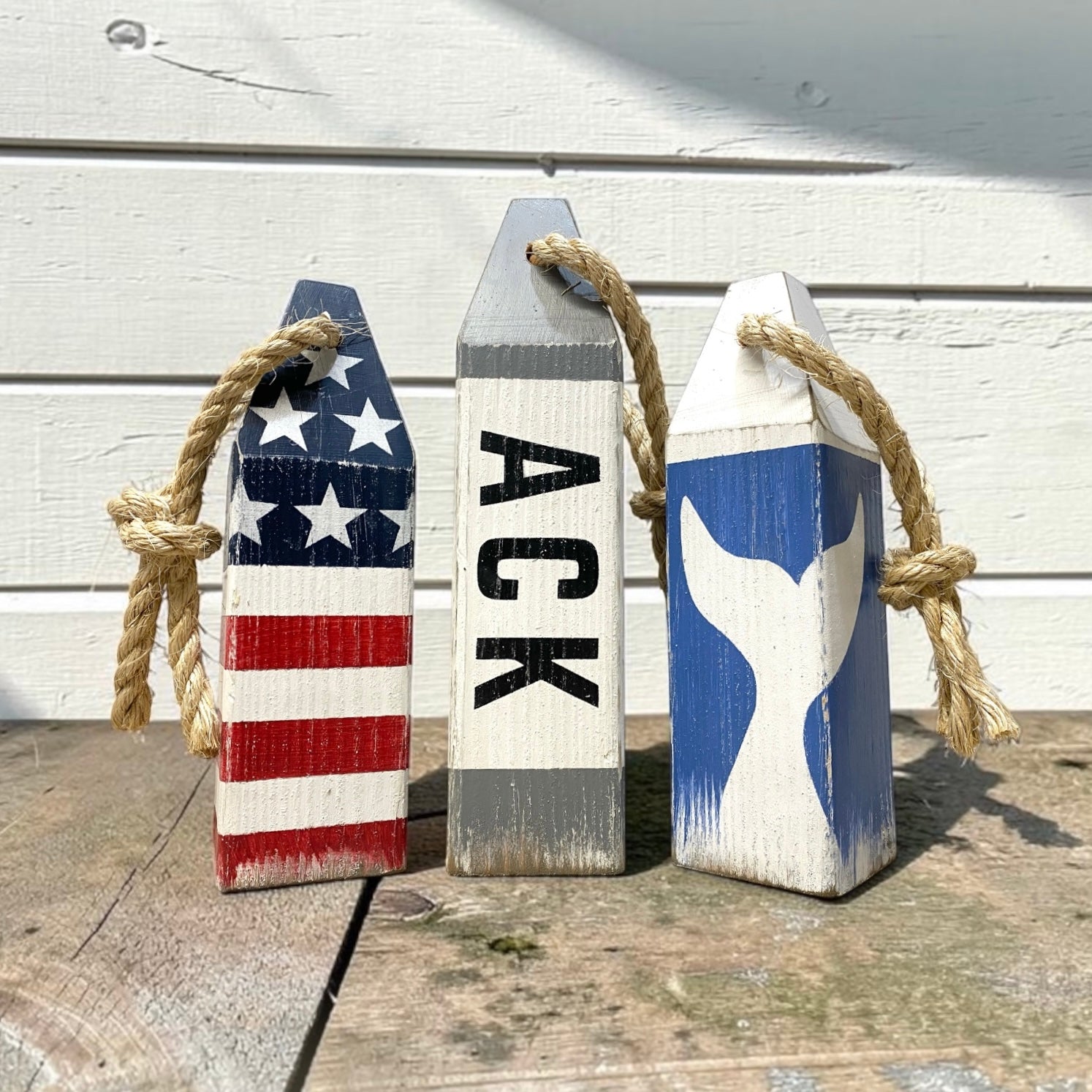 Decorative Nantucket buoy set displayed in a beach house with nautical coastal decor. Handmade wood accents for beach houses, coastal cottages, seaside retreats, and waterfront spaces.