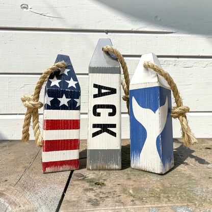Decorative Nantucket buoy set displayed in a beach house with nautical coastal decor. Handmade wood accents for beach houses, coastal cottages, seaside retreats, and waterfront spaces.