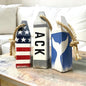 Decorative Nantucket wood buoy set featuring ACK lettering, whale tail design, and patriotic American flag details with a distressed finish. Nautical coastal decor for beach houses, coastal cottages, seaside rooms, waterfront homes, and New England decor
