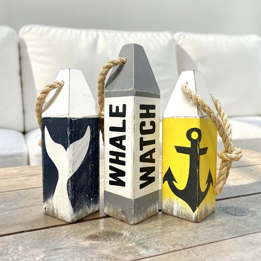 Nautical whale watch buoy set featuring a whale tail and anchor design in sun-washed yellow and deep blue sea colors. Vintage distressed nautical decor inspired by New England’s coastline from Nantucket to Bar Harbor Maine, whale watching memories, ocean history, and the relaxed feeling of beach houses, cottages, and coastal homes.