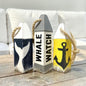 Nautical whale watch buoy set featuring a whale tail and anchor design in sun-washed yellow and deep blue sea colors. Vintage distressed nautical decor inspired by New England’s coastline from Nantucket to Bar Harbor Maine, whale watching memories, ocean history, and the relaxed feeling of beach houses, cottages, and coastal homes.